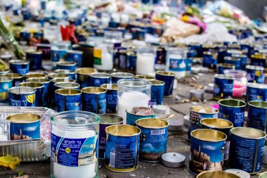 Tel Aviv, İsrail - 10 Nisan 2022 Dizengoff Caddesi 'ndeki Ilka Bar' a düzenlenen terörist saldırının ardından insanlar saldırının gerçekleştiği yere mum ve çiçek bırakmak için geliyorlar.