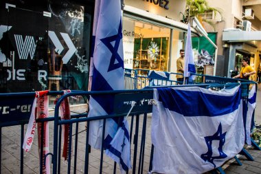 Tel Aviv, İsrail - 10 Nisan 2022 Dizengoff Caddesi 'ndeki Ilka Bar' a düzenlenen terörist saldırının ardından insanlar saldırının gerçekleştiği yere mum ve çiçek bırakmak için geliyorlar.