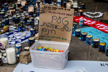Tel Aviv, İsrail - 10 Nisan 2022 Dizengoff Caddesi 'ndeki Ilka Bar' a düzenlenen terörist saldırının ardından insanlar saldırının gerçekleştiği yere mum ve çiçek bırakmak için geliyorlar.