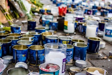 Tel Aviv, İsrail - 10 Nisan 2022 Dizengoff Caddesi 'ndeki Ilka Bar' a düzenlenen terörist saldırının ardından insanlar saldırının gerçekleştiği yere mum ve çiçek bırakmak için geliyorlar.