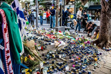 Tel Aviv, İsrail - 10 Nisan 2022 Dizengoff Caddesi 'ndeki Ilka Bar' a düzenlenen terörist saldırının ardından insanlar saldırının gerçekleştiği yere mum ve çiçek bırakmak için geliyorlar.
