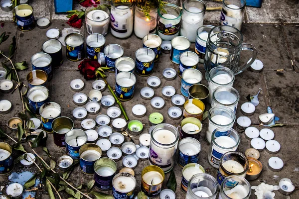 Tel Aviv, İsrail - 10 Nisan 2022 Dizengoff Caddesi 'ndeki Ilka Bar' a düzenlenen terörist saldırının ardından insanlar saldırının gerçekleştiği yere mum ve çiçek bırakmak için geliyorlar.