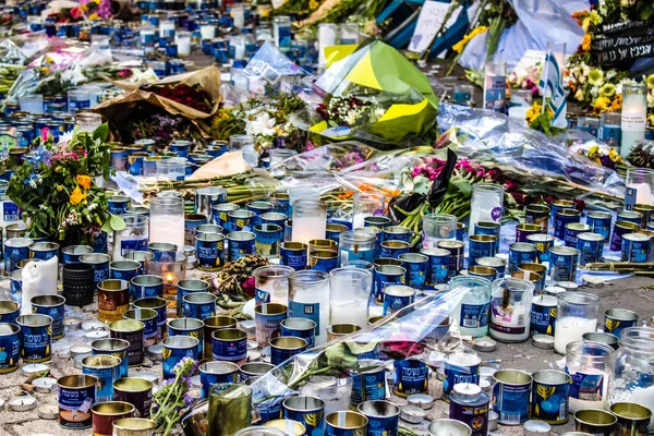 Tel Aviv, İsrail - 10 Nisan 2022 Dizengoff Caddesi 'ndeki Ilka Bar' a düzenlenen terörist saldırının ardından insanlar saldırının gerçekleştiği yere mum ve çiçek bırakmak için geliyorlar.