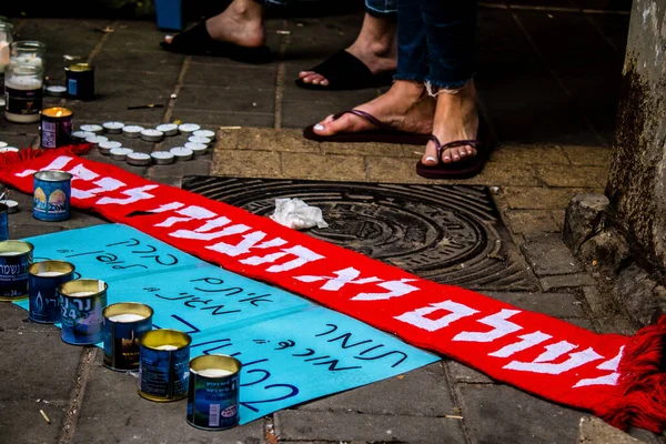 Tel Aviv, İsrail - 10 Nisan 2022 Dizengoff Caddesi 'ndeki Ilka Bar' a düzenlenen terörist saldırının ardından insanlar saldırının gerçekleştiği yere mum ve çiçek bırakmak için geliyorlar.