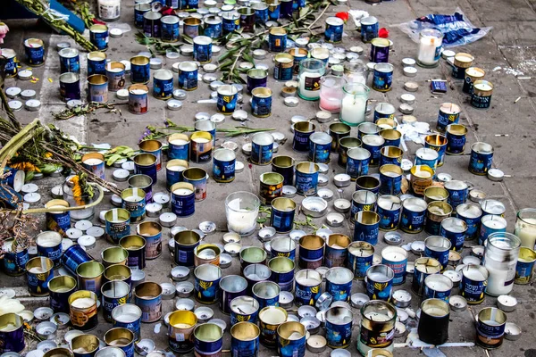 Tel Aviv, İsrail - 10 Nisan 2022 Dizengoff Caddesi 'ndeki Ilka Bar' a düzenlenen terörist saldırının ardından insanlar saldırının gerçekleştiği yere mum ve çiçek bırakmak için geliyorlar.