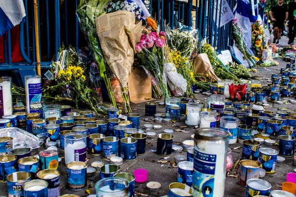 Tel Aviv, İsrail - 10 Nisan 2022 Dizengoff Caddesi 'ndeki Ilka Bar' a düzenlenen terörist saldırının ardından insanlar saldırının gerçekleştiği yere mum ve çiçek bırakmak için geliyorlar.