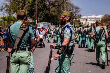 Seville, İspanya - 01 Mayıs 2022 İspanyol Lejyonu 'ndan profesyonel askerlerin geçidi, İspanyol Ordusu' nun bu askeri birliği Feria 'nın fırlatılması için Seville sokaklarında geçit töreni düzenliyor.