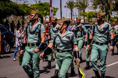 Seville, İspanya - 01 Mayıs 2022 İspanyol Lejyonu 'ndan profesyonel askerlerin geçidi, İspanyol Ordusu' nun bu askeri birliği Feria 'nın fırlatılması için Seville sokaklarında geçit töreni düzenliyor.