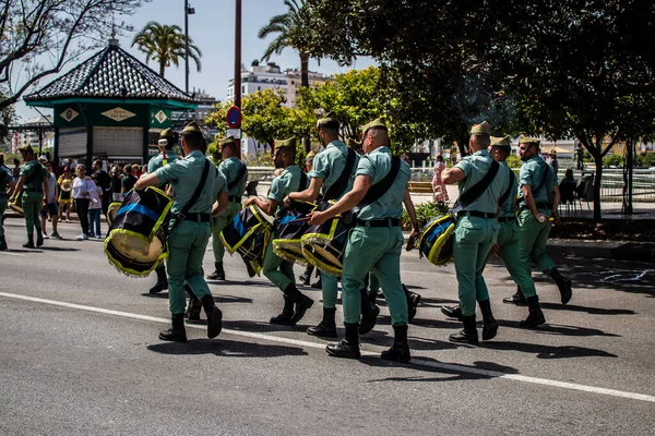 Seville, İspanya - 01 Mayıs 2022 İspanyol Lejyonu 'ndan profesyonel askerlerin geçidi, İspanyol Ordusu' nun bu askeri birliği Feria 'nın fırlatılması için Seville sokaklarında geçit töreni düzenliyor.