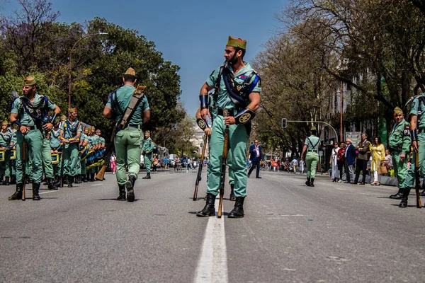 Seville, İspanya - 01 Mayıs 2022 İspanyol Lejyonu 'ndan profesyonel askerlerin geçidi, İspanyol Ordusu' nun bu askeri birliği Feria 'nın fırlatılması için Seville sokaklarında geçit töreni düzenliyor.