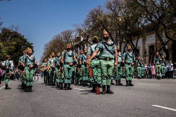 Seville, İspanya - 01 Mayıs 2022 İspanyol Lejyonu 'ndan profesyonel askerlerin geçidi, İspanyol Ordusu' nun bu askeri birliği Feria 'nın fırlatılması için Seville sokaklarında geçit töreni düzenliyor.