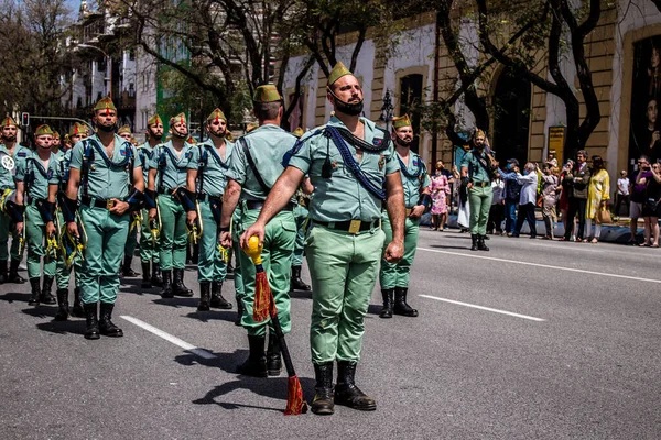 Seville, İspanya - 01 Mayıs 2022 İspanyol Lejyonu 'ndan profesyonel askerlerin geçidi, İspanyol Ordusu' nun bu askeri birliği Feria 'nın fırlatılması için Seville sokaklarında geçit töreni düzenliyor.