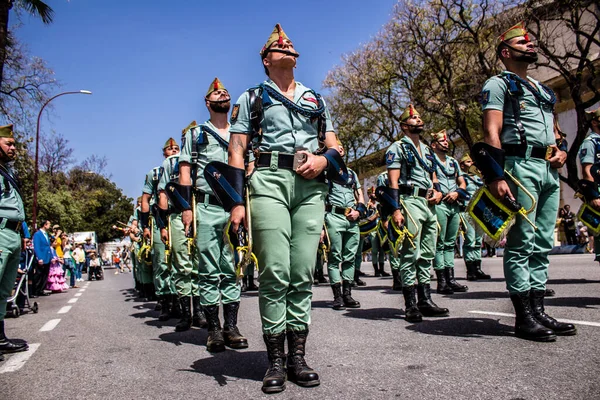 Seville, İspanya - 01 Mayıs 2022 İspanyol Lejyonu 'ndan profesyonel askerlerin geçidi, İspanyol Ordusu' nun bu askeri birliği Feria 'nın fırlatılması için Seville sokaklarında geçit töreni düzenliyor.