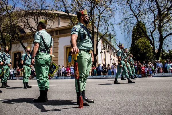 Seville, İspanya - 01 Mayıs 2022 İspanyol Lejyonu 'ndan profesyonel askerlerin geçidi, İspanyol Ordusu' nun bu askeri birliği Feria 'nın fırlatılması için Seville sokaklarında geçit töreni düzenliyor.