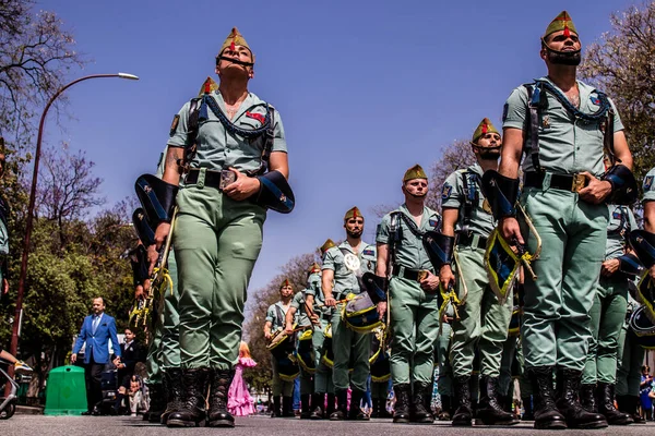 Seville, İspanya - 01 Mayıs 2022 İspanyol Lejyonu 'ndan profesyonel askerlerin geçidi, İspanyol Ordusu' nun bu askeri birliği Feria 'nın fırlatılması için Seville sokaklarında geçit töreni düzenliyor.