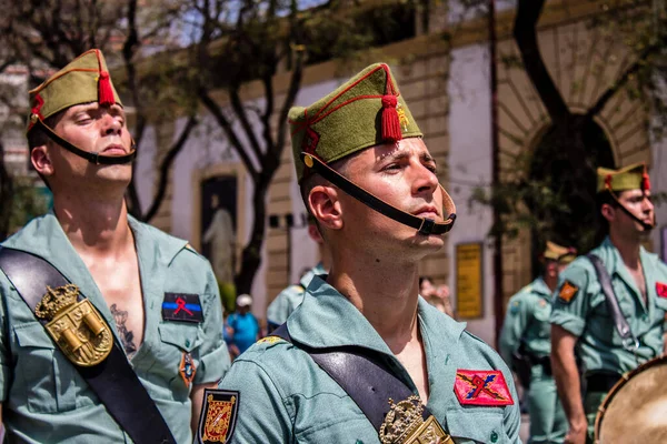 Seville, İspanya - 01 Mayıs 2022 İspanyol Lejyonu 'ndan profesyonel askerlerin geçidi, İspanyol Ordusu' nun bu askeri birliği Feria 'nın fırlatılması için Seville sokaklarında geçit töreni düzenliyor.