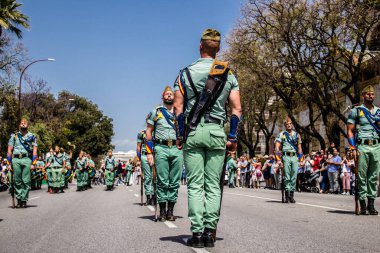 Seville, İspanya - 01 Mayıs 2022 İspanyol Lejyonu 'ndan profesyonel askerlerin geçidi, İspanyol Ordusu' nun bu askeri birliği Feria 'nın fırlatılması için Seville sokaklarında geçit töreni düzenliyor.