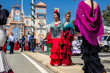 Seville, İspanya - 1 Mayıs 2022 Sevillianlar geleneksel Endülüs tarzında giyinmiş bir at arabasıyla İspanya 'nın en ünlü festivali olan Feria de Sevilla' nın koridorlarında dolaşıyorlar.