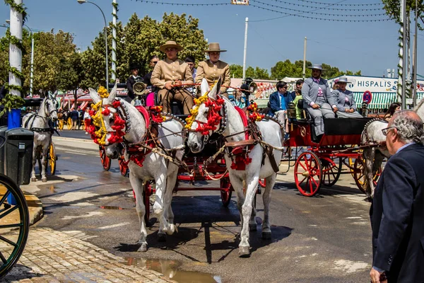 セビリア スペイン 2022年5月1日スペインで最も有名な祭りであるセビリア セビリアの通路を通って馬車に乗る伝統的なアンダルシアの方法で身に着けているセビリア人 — ストック写真