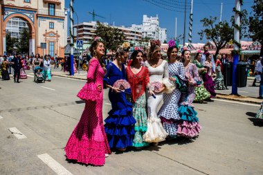 Seville, İspanya - 1 Mayıs 2022 Sevilla 'lılar geleneksel Endülüs tarzında giyinmiş Feria de Seville koridorlarında dolaşıyorlar.