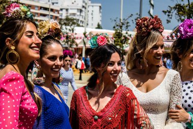 Seville, İspanya - 1 Mayıs 2022 Sevilla 'lılar geleneksel Endülüs tarzında giyinmiş Feria de Seville koridorlarında dolaşıyorlar.