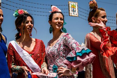Seville, İspanya - 1 Mayıs 2022 Sevilla 'lılar geleneksel Endülüs tarzında giyinmiş Feria de Seville koridorlarında dolaşıyorlar.