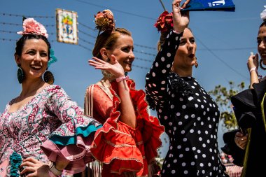 Seville, Spain - May 01, 2022 Sevillians dressed in traditional Andalusian way strolling the aisles of the Feria de Seville, This celebration is back after two years of absence due to covid epidemic