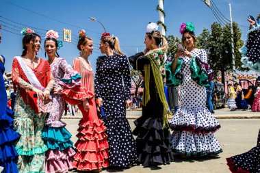 Seville, Spain - May 01, 2022 Sevillians dressed in traditional Andalusian way strolling the aisles of the Feria de Seville, This celebration is back after two years of absence due to covid epidemic