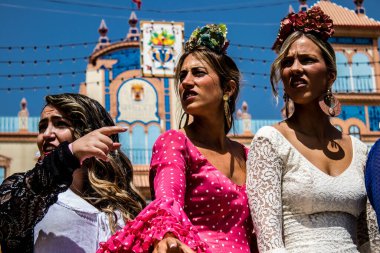 Seville, İspanya - 1 Mayıs 2022 Sevilla 'lılar geleneksel Endülüs tarzında giyinmiş Feria de Seville koridorlarında dolaşıyorlar.