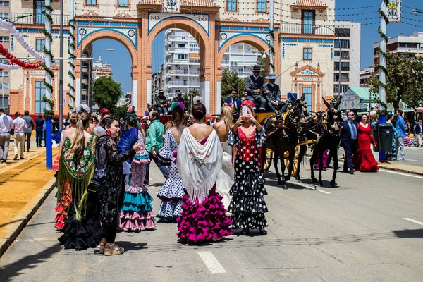 Seville, İspanya - 1 Mayıs 2022 Sevilla 'lılar geleneksel Endülüs tarzında giyinmiş Feria de Seville koridorlarında dolaşıyorlar.