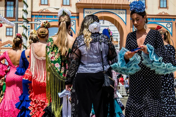 Seville, İspanya - 1 Mayıs 2022 Sevilla 'lılar geleneksel Endülüs tarzında giyinmiş Feria de Seville koridorlarında dolaşıyorlar.