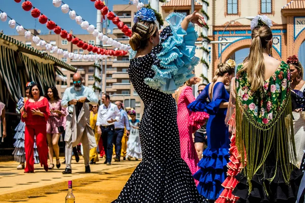 Seville, İspanya - 1 Mayıs 2022 Sevilla 'lılar geleneksel Endülüs tarzında giyinmiş Feria de Seville koridorlarında dolaşıyorlar.
