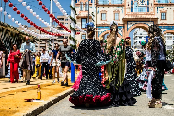 Seville, İspanya - 1 Mayıs 2022 Sevilla 'lılar geleneksel Endülüs tarzında giyinmiş Feria de Seville koridorlarında dolaşıyorlar.