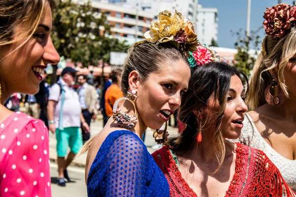 Seville, İspanya - 1 Mayıs 2022 Sevilla 'lılar geleneksel Endülüs tarzında giyinmiş Feria de Seville koridorlarında dolaşıyorlar.