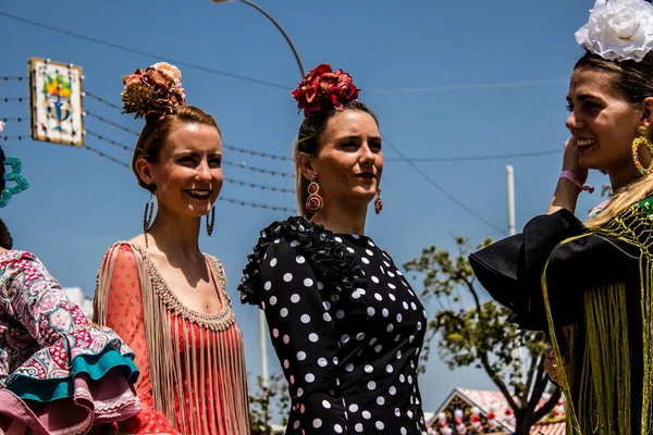 Seville, İspanya - 1 Mayıs 2022 Sevilla 'lılar geleneksel Endülüs tarzında giyinmiş Feria de Seville koridorlarında dolaşıyorlar.