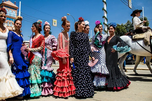 Seville, İspanya - 1 Mayıs 2022 Sevilla 'lılar geleneksel Endülüs tarzında giyinmiş Feria de Seville koridorlarında dolaşıyorlar.