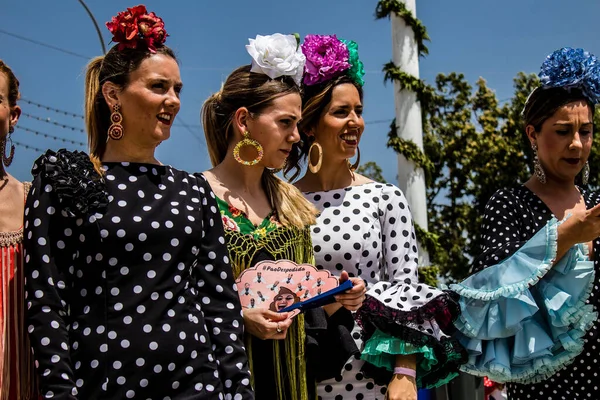 Seville, Spain - May 01, 2022 Sevillians dressed in traditional Andalusian way strolling the aisles of the Feria de Seville, This celebration is back after two years of absence due to covid epidemic