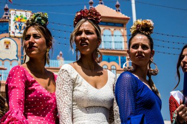 Seville, İspanya - 1 Mayıs 2022 Sevilla 'lılar geleneksel Endülüs tarzında giyinmiş Feria de Seville koridorlarında dolaşıyorlar.