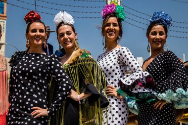 Seville, Spain - May 01, 2022 Sevillians dressed in traditional Andalusian way strolling the aisles of the Feria de Seville, This celebration is back after two years of absence due to covid epidemic