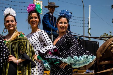Seville, Spain - May 01, 2022 Sevillians dressed in traditional Andalusian way strolling the aisles of the Feria de Seville, This celebration is back after two years of absence due to covid epidemic