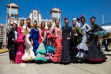 Seville, İspanya - 1 Mayıs 2022 Sevilla 'lılar geleneksel Endülüs tarzında giyinmiş Feria de Seville koridorlarında dolaşıyorlar.