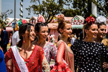 Seville, İspanya - 1 Mayıs 2022 Sevilla 'lılar geleneksel Endülüs tarzında giyinmiş Feria de Seville koridorlarında dolaşıyorlar.
