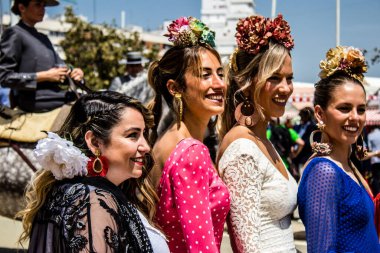Seville, Spain - May 01, 2022 Sevillians dressed in traditional Andalusian way strolling the aisles of the Feria de Seville, This celebration is back after two years of absence due to covid epidemic