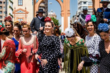 Seville, İspanya - 1 Mayıs 2022 Sevilla 'lılar geleneksel Endülüs tarzında giyinmiş Feria de Seville koridorlarında dolaşıyorlar.