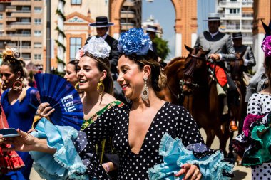 Seville, İspanya - 1 Mayıs 2022 Sevilla 'lılar geleneksel Endülüs tarzında giyinmiş Feria de Seville koridorlarında dolaşıyorlar.