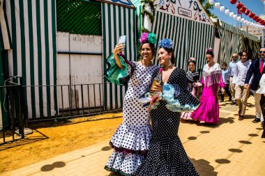 Seville, Spain - May 01, 2022 Sevillians dressed in traditional Andalusian way strolling the aisles of the Feria de Seville, This celebration is back after two years of absence due to covid epidemic
