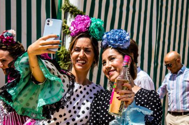 Seville, İspanya - 1 Mayıs 2022 Sevilla 'lılar geleneksel Endülüs tarzında giyinmiş Feria de Seville koridorlarında dolaşıyorlar.