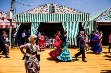 Seville, İspanya - 1 Mayıs 2022 Sevilla 'lılar geleneksel Endülüs tarzında giyinmiş Feria de Seville koridorlarında dolaşıyorlar.