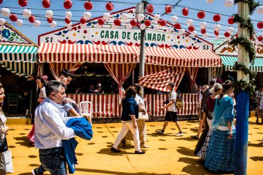 Seville, İspanya - 1 Mayıs 2022 Sevilla 'lılar geleneksel Endülüs tarzında giyinmiş Feria de Seville koridorlarında dolaşıyorlar.