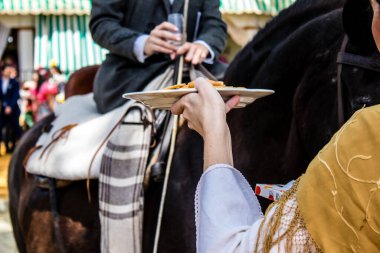 Seville, İspanya - 1 Mayıs 2022 Sevilla 'lılar geleneksel Endülüs tarzında giyinmiş Feria de Seville koridorlarında dolaşıyorlar.